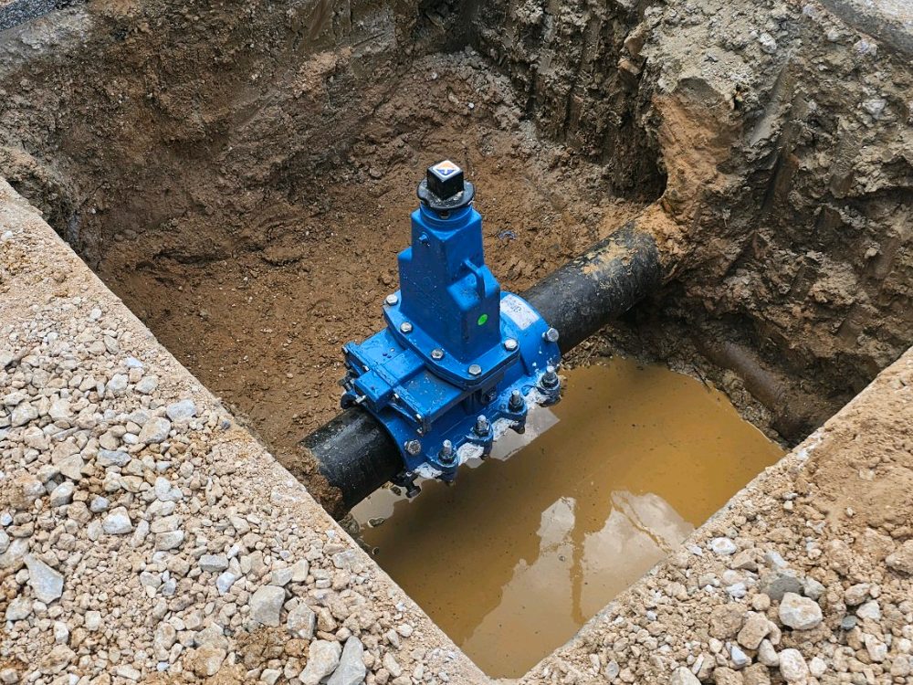 Blue EZ Valve insertion valve installed on an exposed water main in an excavation
